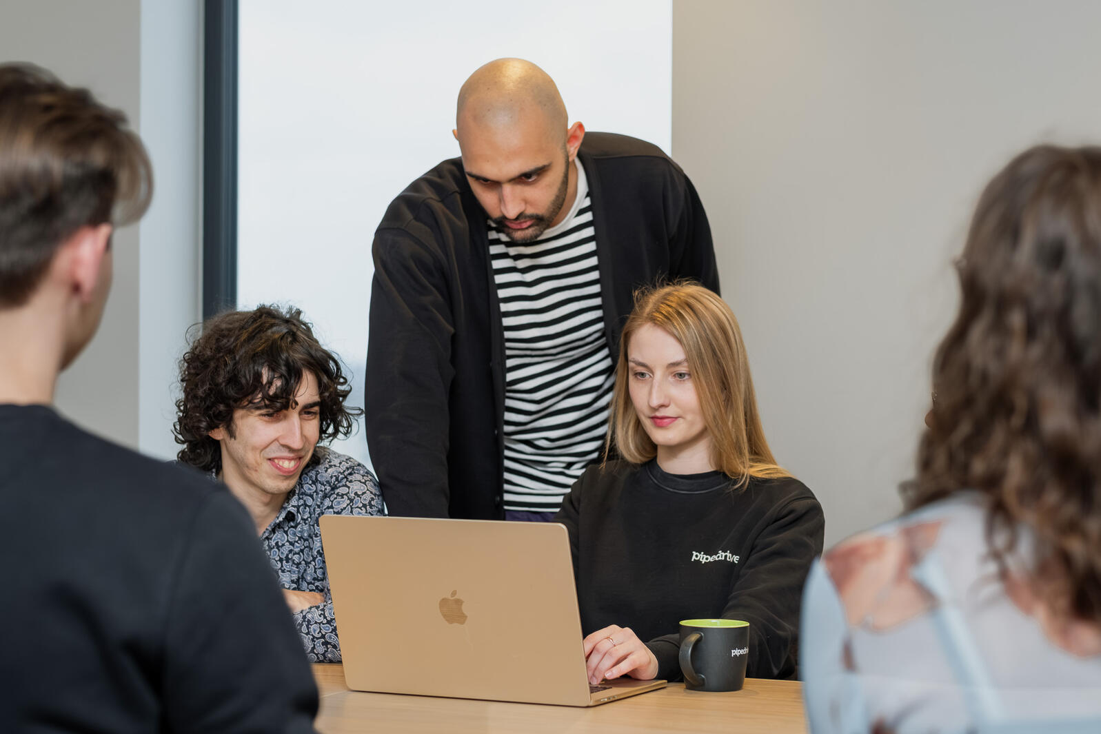 Pipedrive meeskond koos sülearvuti ümber töökoosolekul